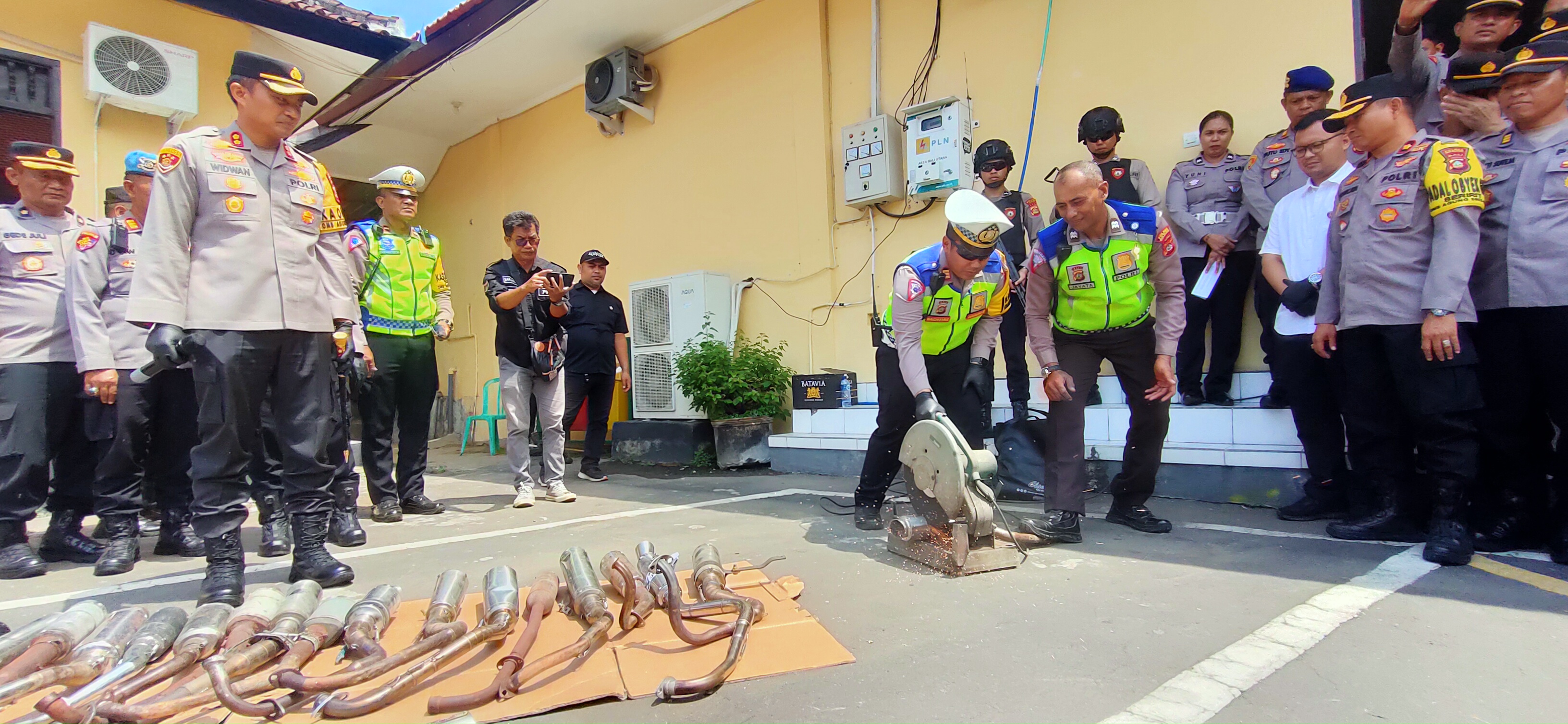 GERGAJI: Knalpot brong yang disita langsung dipotong menggunakan gergaji besi.