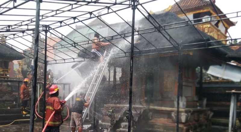 BERJIBAKU PADAMKAN API : Petugas pemadam kebakaran saat melakukan pemadaman api yang melahap bangunan pura di Lingkungan Gede, Kelurahan Subagan, Karangasem,Senin (1/1/2023). (Foto Disdamkartan)