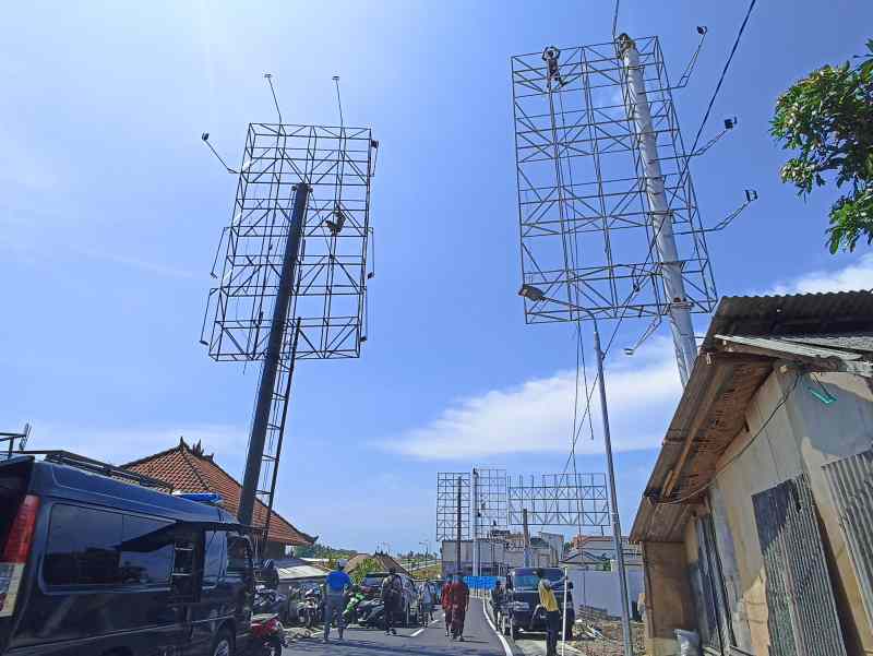 DIBONGKAR : Papan tempat iklan di simpang Tibuneneng-Canggu ini dibongkar. (adrian suwanto/radar bali)