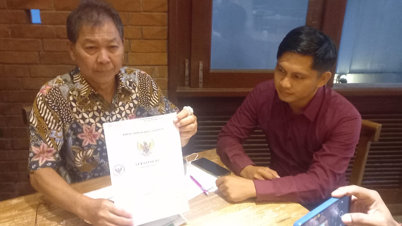 MINTA PERLINDUNGAN HUKUM: Nyoman Suarsana Handika (kiri) dan Kuasa Hukumnya I Made Dwiatmiko Aristianto menunjukkan SHM, Jumat (12/1/2024). (Tim Nyoman Suarsana Handika)
