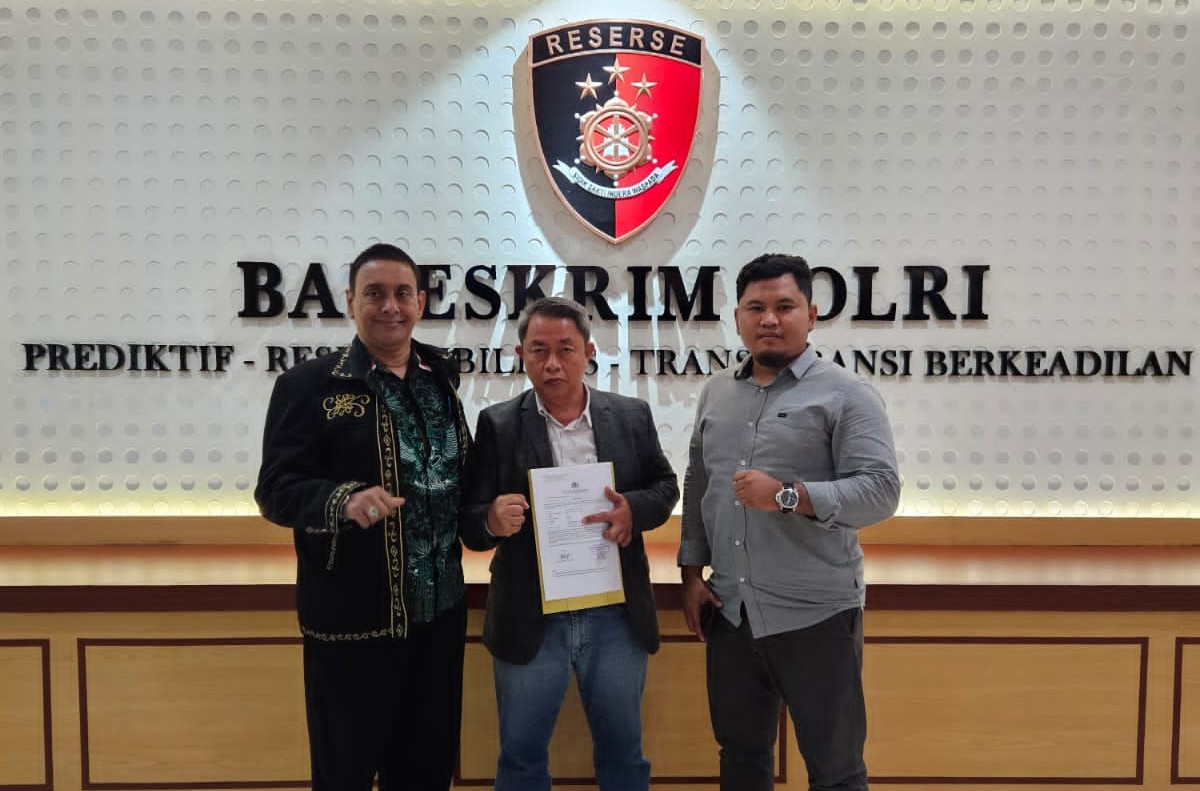 PENEGAKAN HUKUM: Tim Komisi Hukum MUI Provinsi Bali Agus Samijaya (tengah pegang bukti laporan) didampingi Zainal Abidin (kanan) dan Tim Advokasi Hukum MUI Pusat Azham Khan (kiri) di Bareskrim Polri