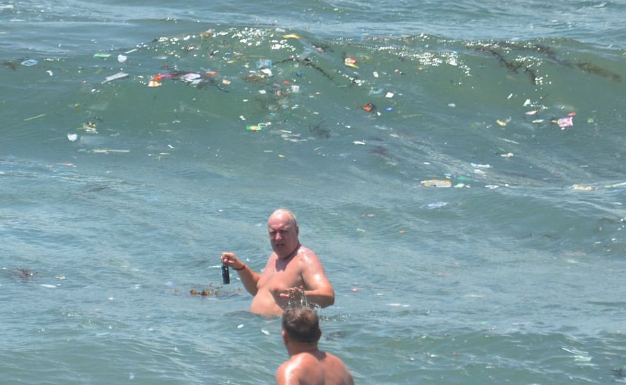 DISOROT: Wisatawan asing tampak berenang ditengah kepungan sampah laut Pantai Kuta, Sabtu 13 Januari 2024.