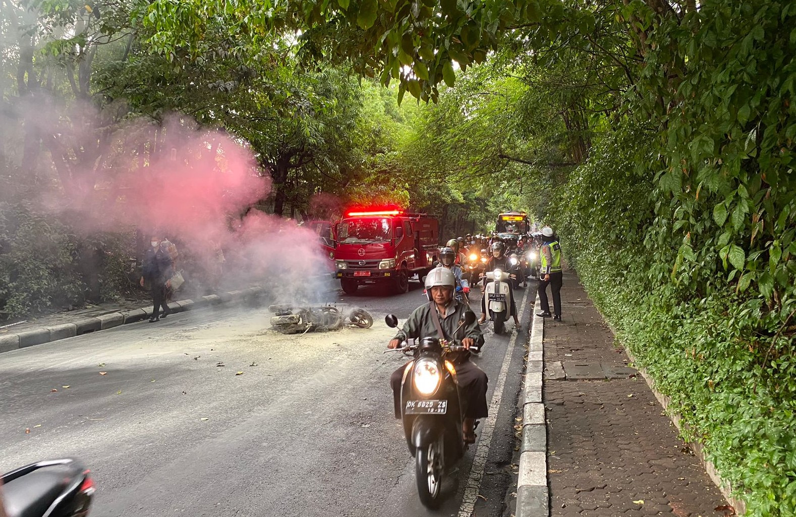 HANGUS: Sebuah sepeda motor NMAX yang hangus terbakar di jalan raya mengakibatkan kemacetan panjang.