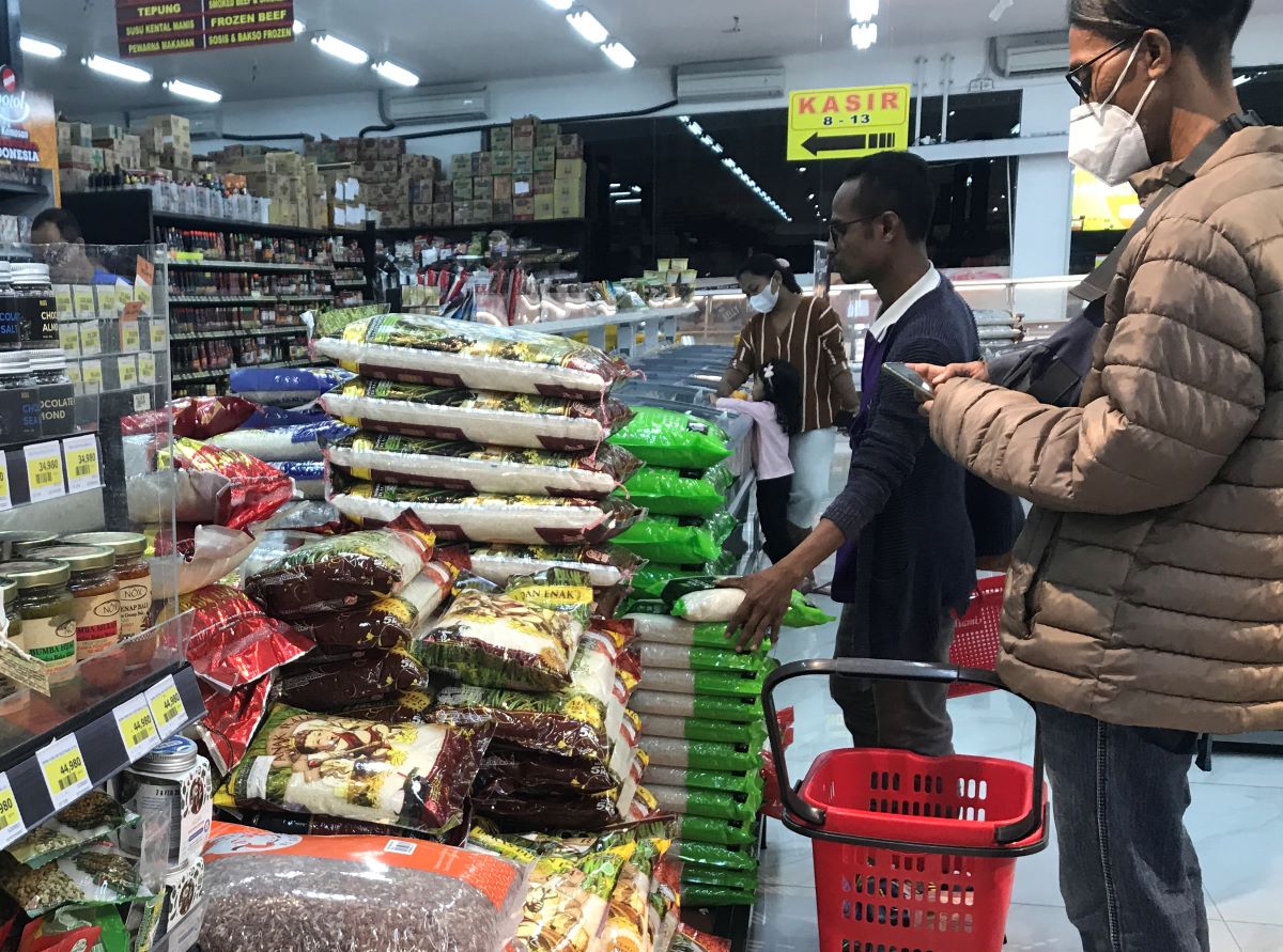 BERAT: Salah seorang warga saat belanja  beras di salah satu supermarket di Denpasar beberapa hari lalu.
