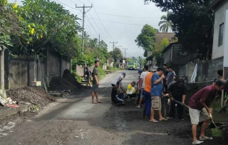 SWADAYA BERGOTONG ROYONG : Warga Desa Selat saat melakukan aktivitas perbaikan jalan milik provinsi akibat tidak kunjung diperbaiki. (foto:Istimewa)