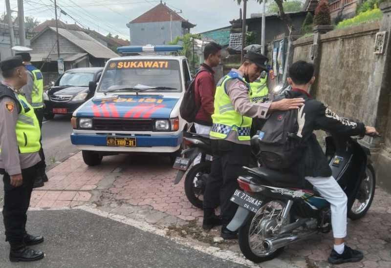 GELAR RAZIA DEKAT SEKOLAH : Petugas melakukan razia di pintu masuk sekolah SMAN 1 Sukawati. (Istimewa)