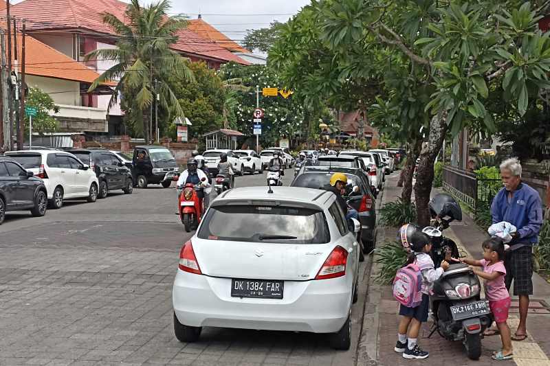 PARKIR KANAN -KIRI : Kondisi kendaraan yang parker di Jalan Kamboja Denpasar. Kanan dan kiri bahu jalan dipakai parker.(adrian suwanto/radar bali)