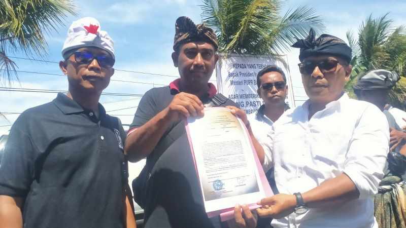 TUNJUKKAN SURAT : Ketua Forum Perbekel Terdampak Jalan Tol Mengwi-Gilimanuk I Nyoman Arnawa didampingi Perbekel Desa Antosari I Nyoman Agus Suryawan menunjukkan surat kepada Presiden Jokowi.(juliadi)