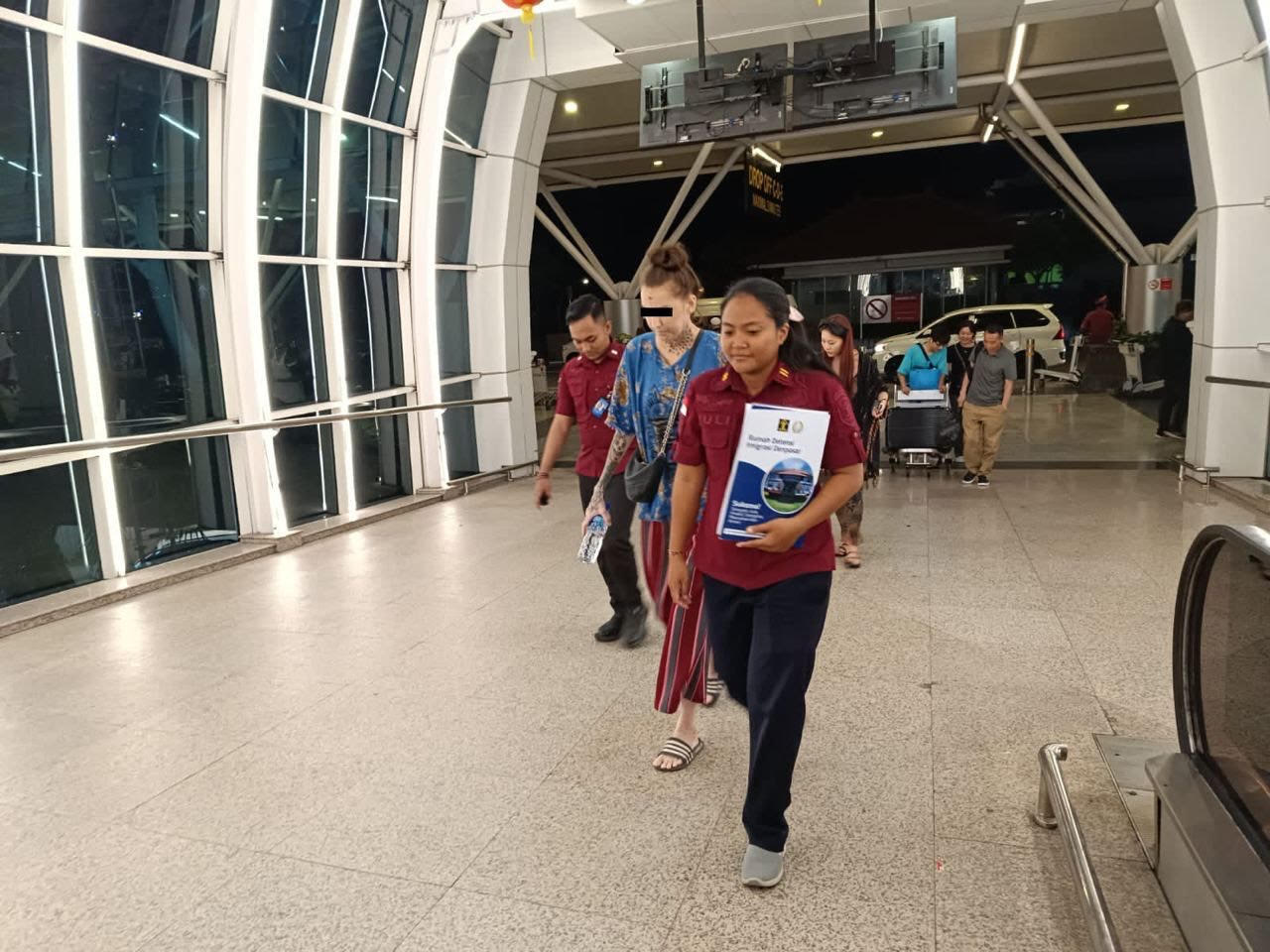 DEPORTASI: Petugas memandu WNA Republik Ceko berinisial MS pulang ke negaranya saat di Bandara Internasional Ngurah Rai Denpasar