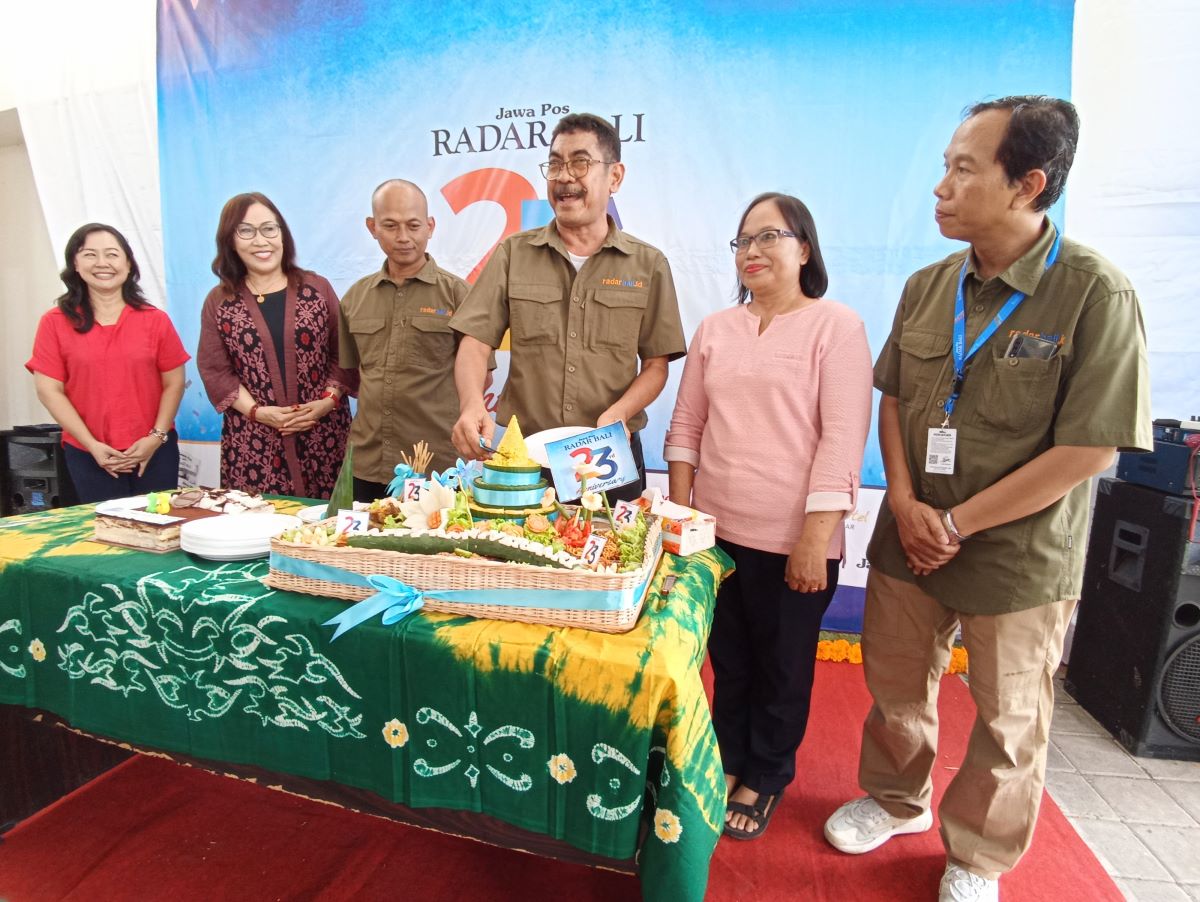 Direktur Jawa Pos Radar Bali Justin M. Herman (tengah) saat memotong tumpeng didampingi ibu Prihantini, istri alm Prabangsa (12/2/2024)