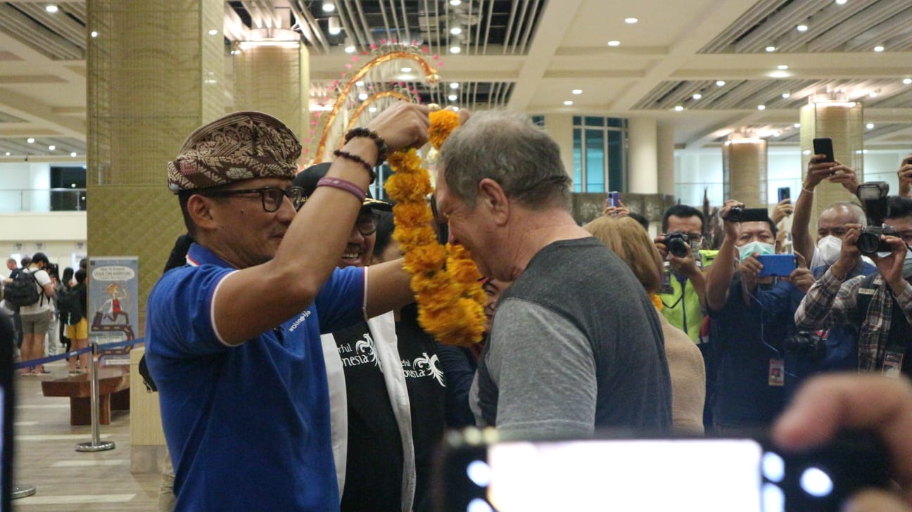 PADAT: Menteri Pariwisata dan Ekonomi Kreatif Sandiaga Uno mengalungkan bunga bagi wisatawan yang baru tiba di Bandara I Gusti Ngyurah Rai beberapa waktu lalu.