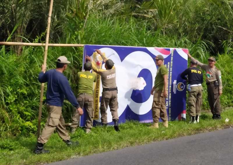 ADA YANG MEMBANDEL : Perugas Satpol PP Kabupaten Karangasem saat melakukan penertiban APK di wilayah Kecamatan Abang pada Minggu (11/2/2024).(istimewa)