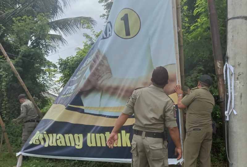 DIBERSIHKAN PAKSA : Gegara banyak yang bandel petugas Pol PP Gianyar menertibkan baliho. (istimewa)