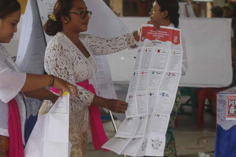 HITUNG SUARA : Petugas KPPS TPS 33 mengecek kertas suara saat pemilu. (miftahuddin/radar bali)