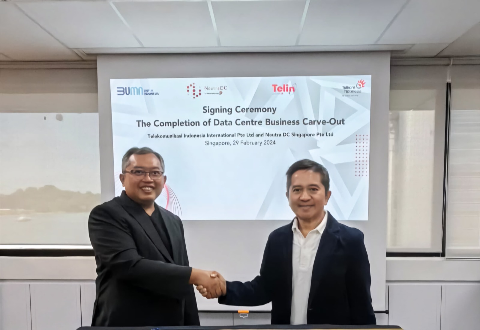 DATA CENTER: CEO NeutraDC Singapore, Sendang Praptomo (kiri) bersama CEO Telin Singapore, Indarto (kanan), saat seremoni penyelesaian proses konsolidasi bisnis data center.