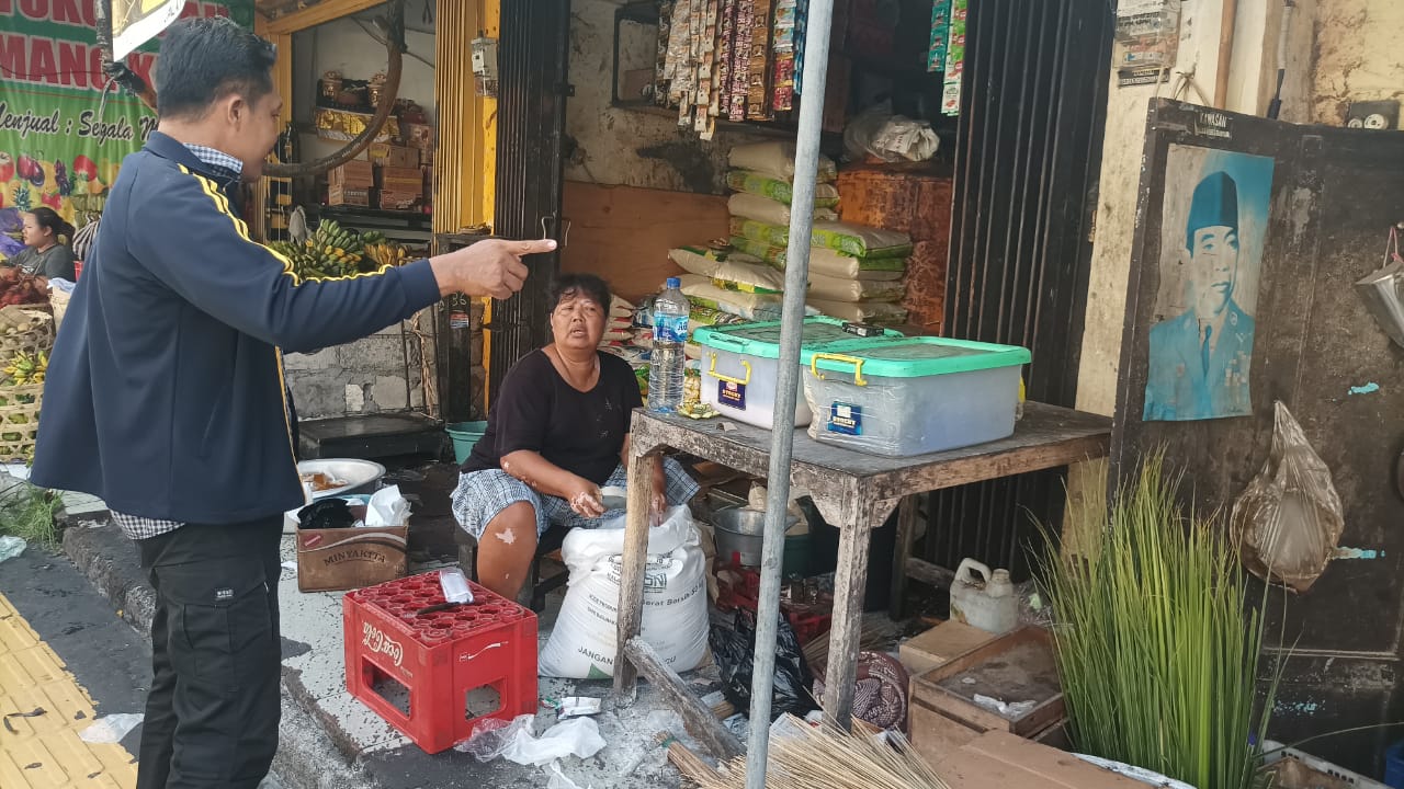 STABIL: Petugas mengecek harga beras di sebuah toko sembako di Gianyar