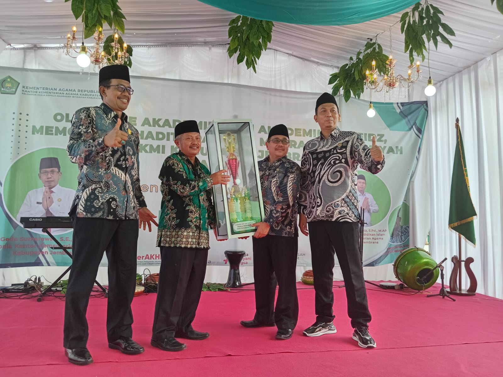 PENYERAHAN PIALA BERGILIR: Kepala Kantor Kemenerian Agama diwakili Kabag TU kepada Kepala MIN 6 Jembrana didampingi Kasi Pendais dan Ketua KKMI Jembrana (9/3/2024). (Matlani/Radar Bali)