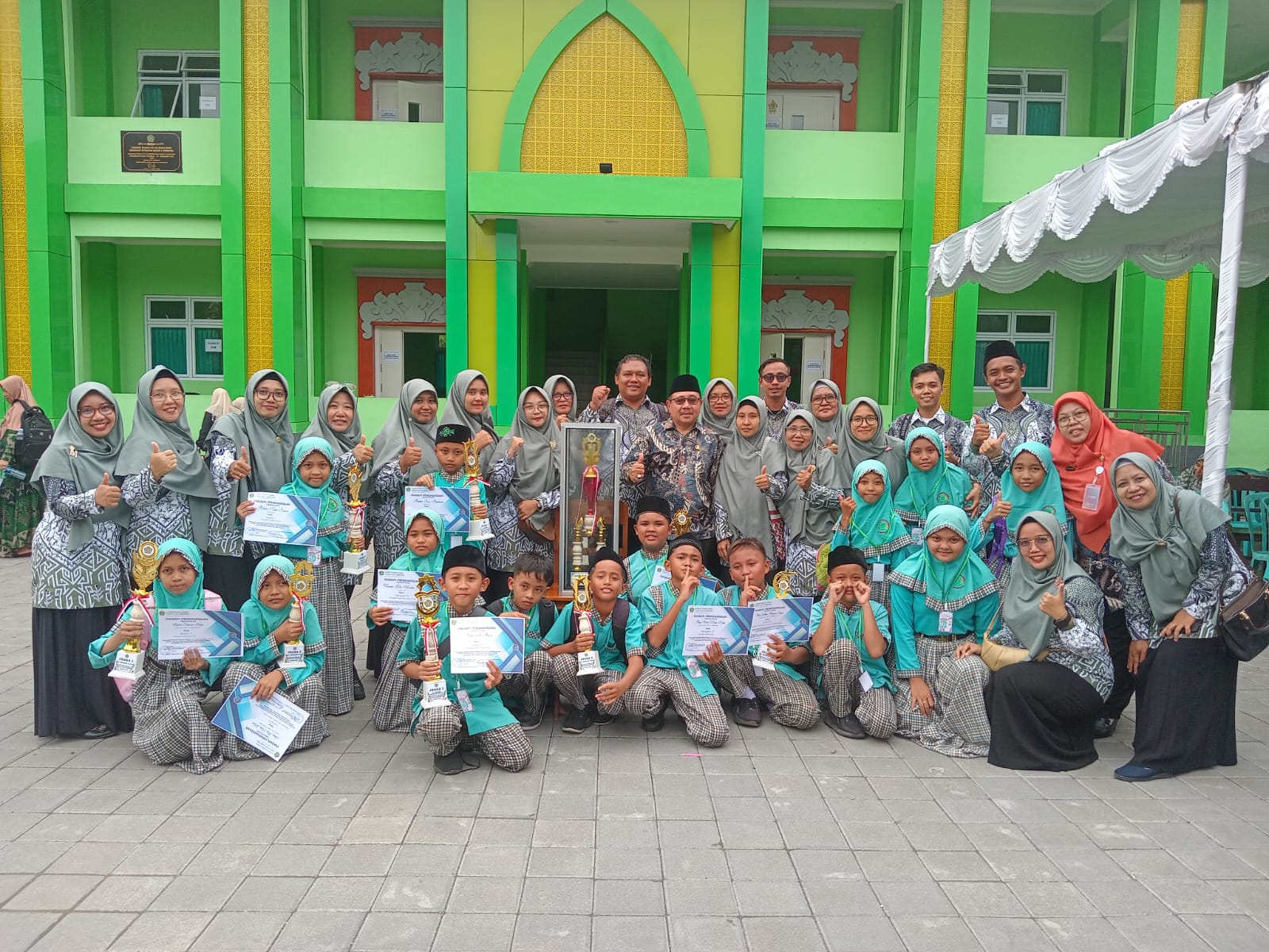 PERAYAAN: Foto bersama Kepala MIN 6 Jembrana bersama siswa-siswi dan guru pembimbing usai menerima piala bergilir (9/3/2024). (Matlani/Radar Bali)