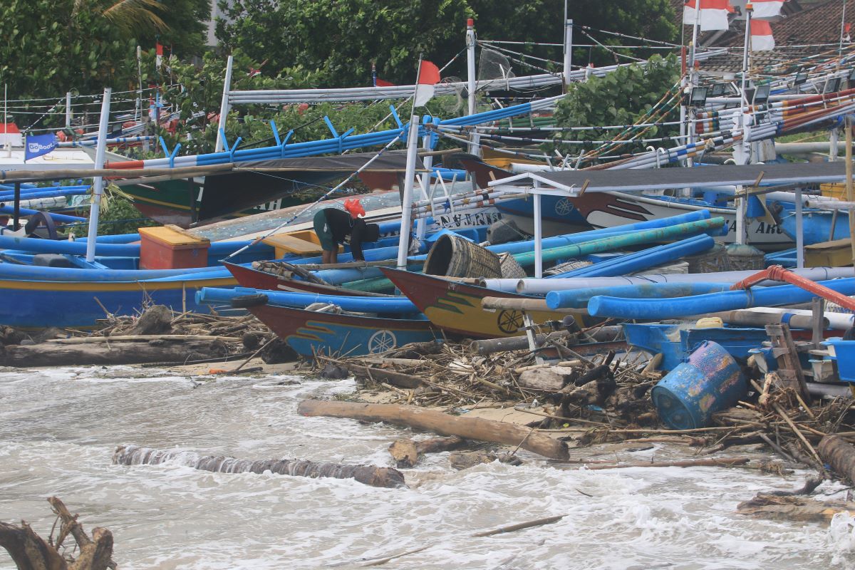 SAMPAH dan GELOMBANG: Sampah yang membanjiri pantai Kedonganan dan gelombang laut yang tinggi membuat nelayan tak melaut memarkir perahunya.