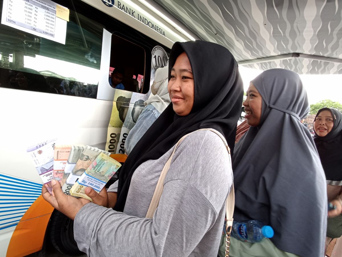 ANGPAO LEBARAN: Sejumlah warga tampak semringah setelah menukar uang baru menjelang Lebaran Idul Fitri layanan Bank Indonesia lewat mobil keliling.