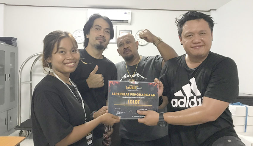 SIMBOLIS: Penyerahan sertifikat oleh Ni Kadek Ayunita selaku koordinator sie acara Wira Bhakti Music Concert kepada Lolot band selaku pengisi acara (30/3/2024). (Dok.Balimampir & Bali Channel)