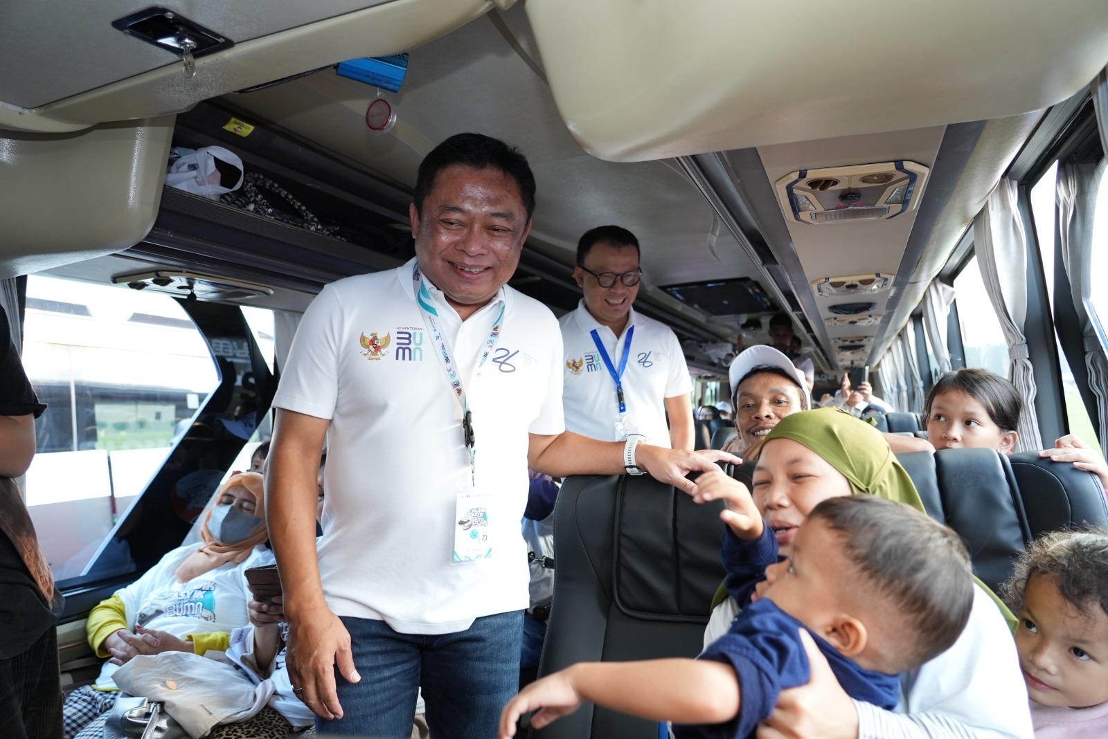 MUDIK ASYIK: Direktur Utama Telkom Ririek Adriansyah (depan) didampingi Direktur Utama Telkomsel Nugroho (belakang) saat berinteraksi dengan pemudik di bus Telkom dalam  Mudik Asyik Bersama BUMN 2024.