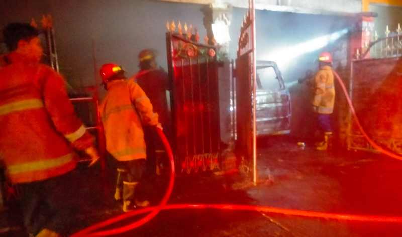 PADAMKAN API : Petugas pemadam kebakaran saat melakukan pemadaman mobil terbakar di garasi di wilayah Jalan Ngurah Rai, Gang Rajawali, Karangasem. (Istimewa)