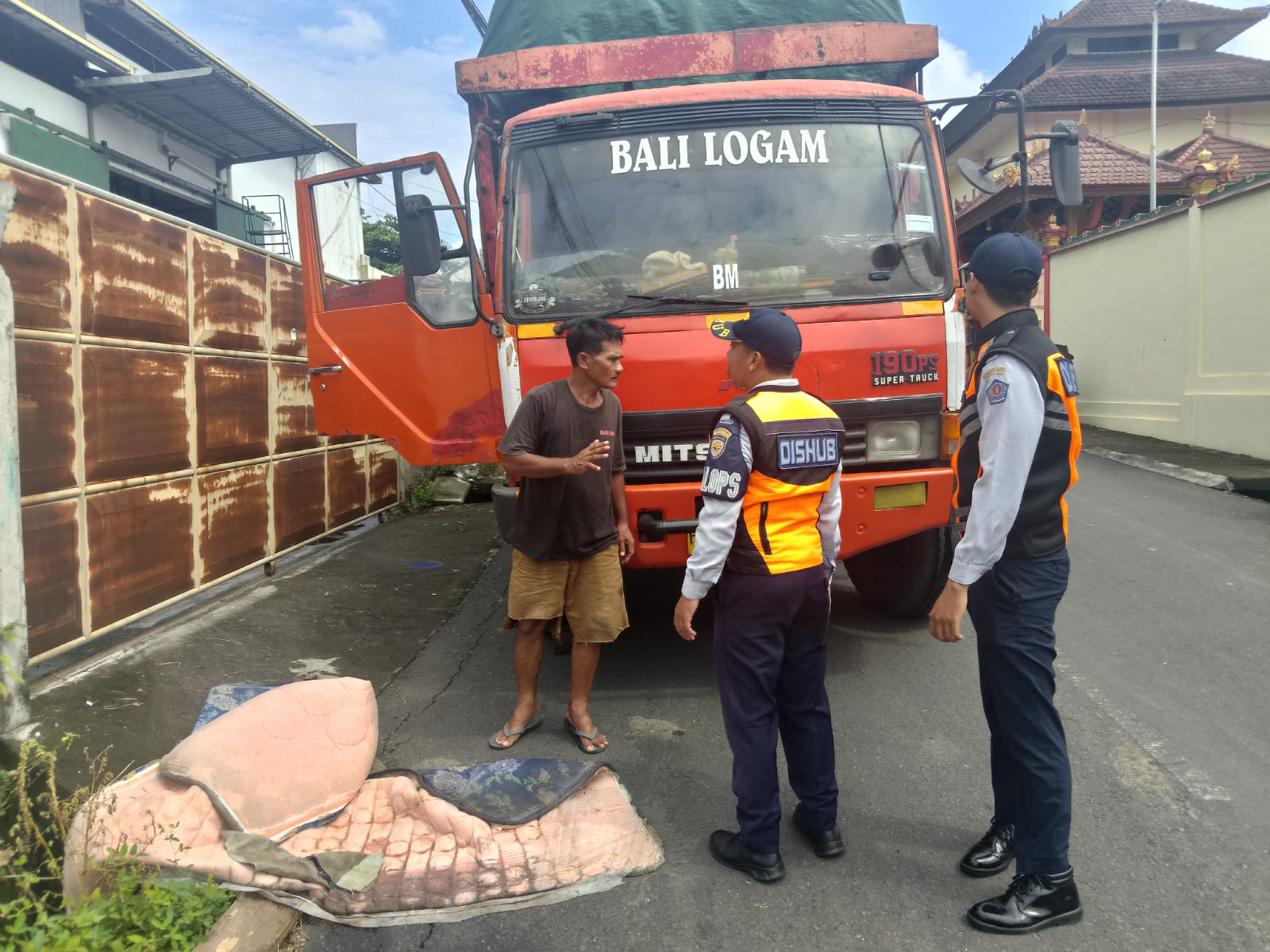 PELANGGAR: Aparat Dinas Perhubungan Kota Denpasar menemui sopir truk yang bongkar muiatan di jalan sempit jalan Fujiama Denpasar.