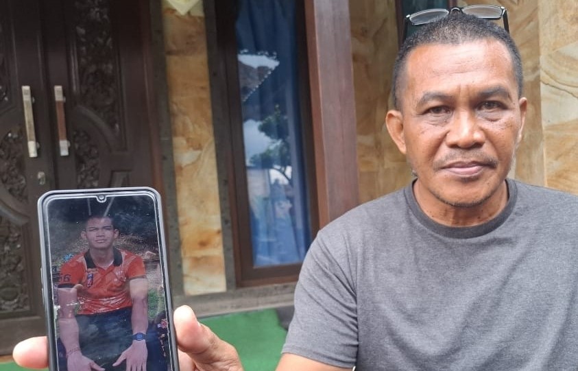 MENGENANG ANAK TERCINTA : Ayah Rustika, Ketut Suastika saat menunjukkan foto Rustika semasa hidup. (dewa ayu pitri arisanti/radar bali)
