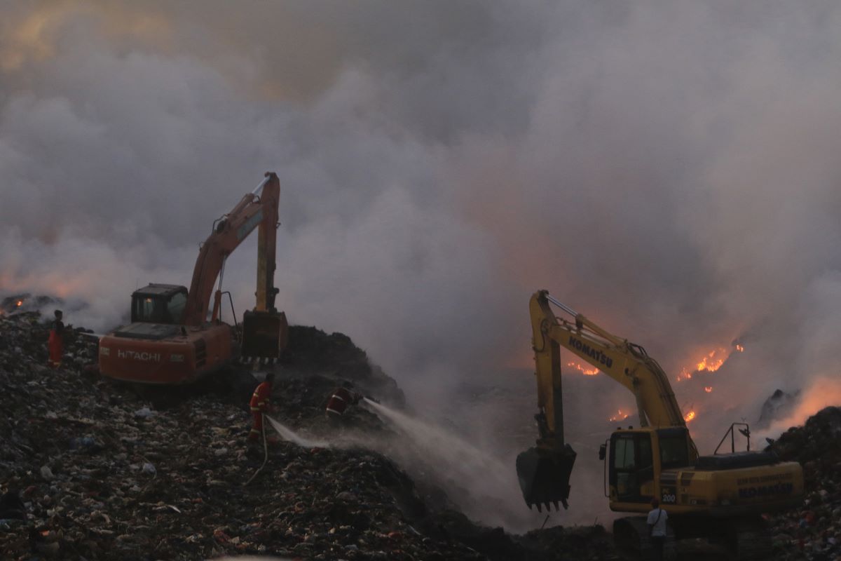 KEMBALI MENCEKAM: Petugas pemadam kebakaran menyemprotkan air ke ttitik kobaran api dan kepulan asap di TPA Suwung Rabu sore, 8 Mei 2024.