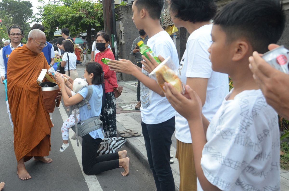 CARI BERKAH: Ratusan umat Budha berjajar di jalan Gunung Agung Denpasar memberikan dana pindapata kepada Bhikku serangkayan Hari Suci Waisak 2568 BE Tahun 2024.