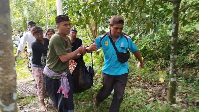 DITEMUKAN SUDAH MENINGGAL : Tim SAR bersama warga melakukan evakuasi terhadap jenazah Nyoman Santra yang hilang selama dua hari. (eka prasetya/radar bali)