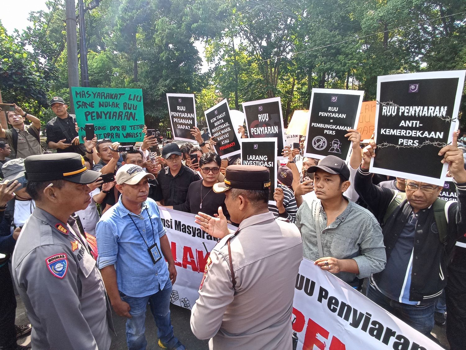 TOPLAK RUU PENYIARAN!: Aliansi Masyarakat Bali Tolak RUU Penyiaran saat melancarkan aksi di depan DPRD Bali sedang negosiasi dengan polisi. Ternyata pimpinan dewan kosong.