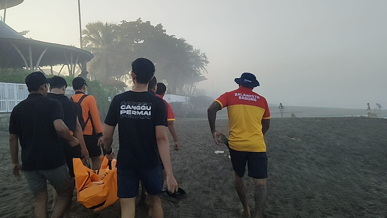 TERDAMPAR: Tim Basarnas saat mengevakuasi jenasah Nando yang tersret arus dan ditemukan ngambang di Pantai Canggu