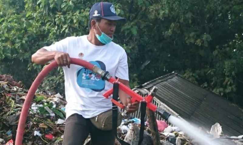 PENYEMPROTAN BERAMAI-RAMAI : Penyemprotan eco enzyme di TPA Mandung oleh DLH Tabanan. (juliadi/radar bali)