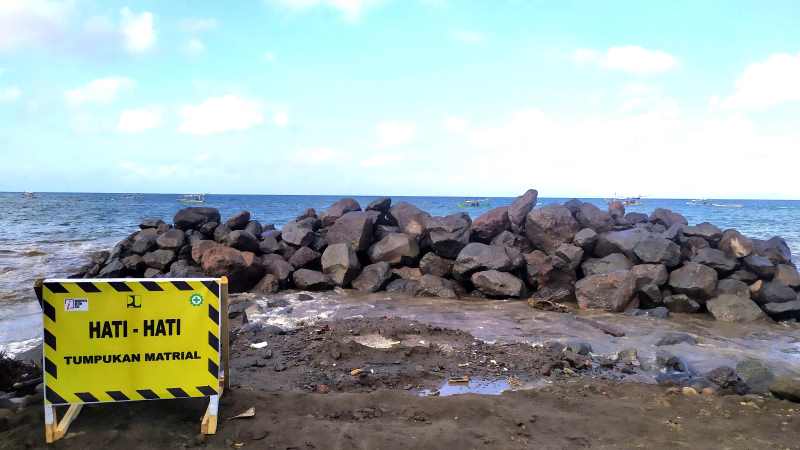 KURANG SAT-SET : Tumpukan material batu armor di pinggir pantai yang akan digunakan untuk senderan pantai.(m. basir/radar bali)