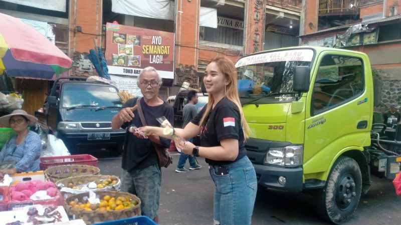 BAGIKAN BUNGA DAN STIKER : Suasana Relawan Semut Tabanan yang membagikan bunga mawar dan stiker Bung Karno kepada para pedagang Pasar Tabanan.(juliadi/radar bali)