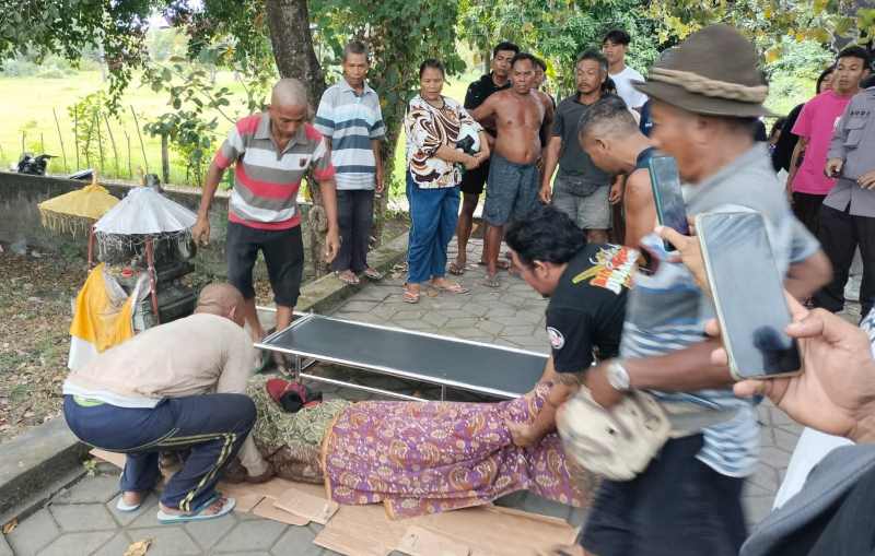 DIDUGA KARENA KELELAHAN: Polisi bersama warga mengevakuasi jenazah sopir yang diduga kelelahan.(foto:polres buleleng)