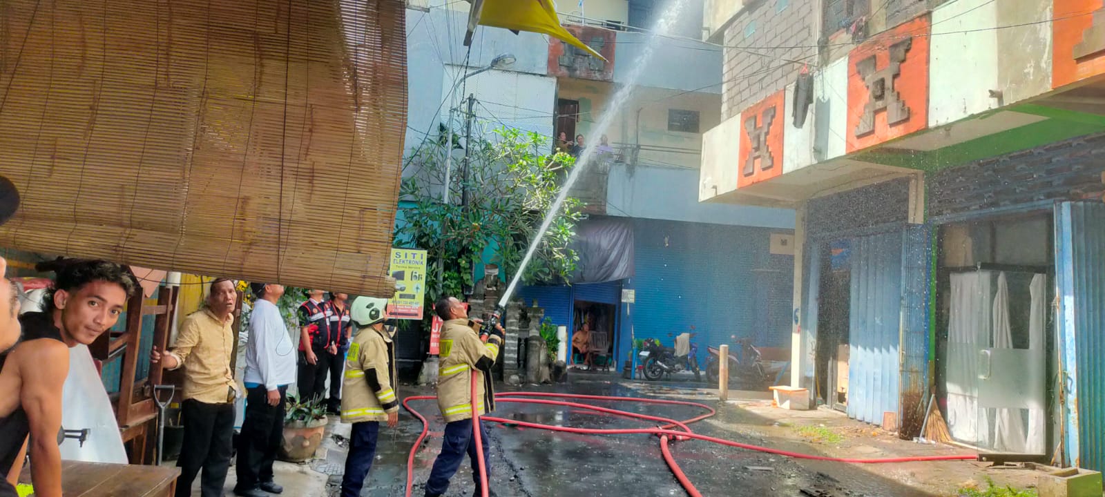 PEMADAMAN: Petugas sedang memadamkan api di Ruko Lantai III, di Jalan Raya Kuta, Gang Selamat, Nomor. 6 Kuta, Badung. Kejadian berlangsung Selasa (18/6/2024).