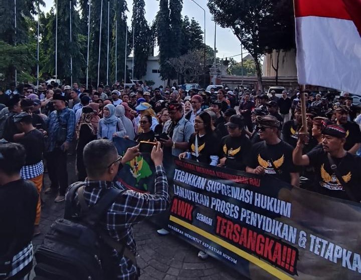 BERSATU: Ratusan peserta aksi  Aliansi Kebhinekaan Bali dengan membentang spanduk di depan Mapolda Bali, 20 Juni 2024.
