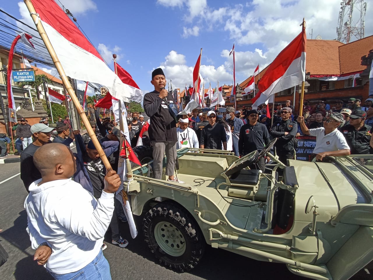 GEDOR POLDA BALI: Korlap aksi Aliansi Kebhinekaan Bali Haskoro saat orasi di ditengah ratusan massa depan Mapolda Bali menuntut AWK ditahan, Kamis 20 Juni 2024.
