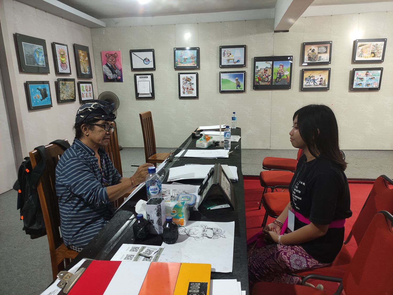 BERKAH PKB: Wayan Tama sedang melayani pengoder karikatur di arena Pesta Kesenian Bali di Art Center Denpasar (24/6/2024)