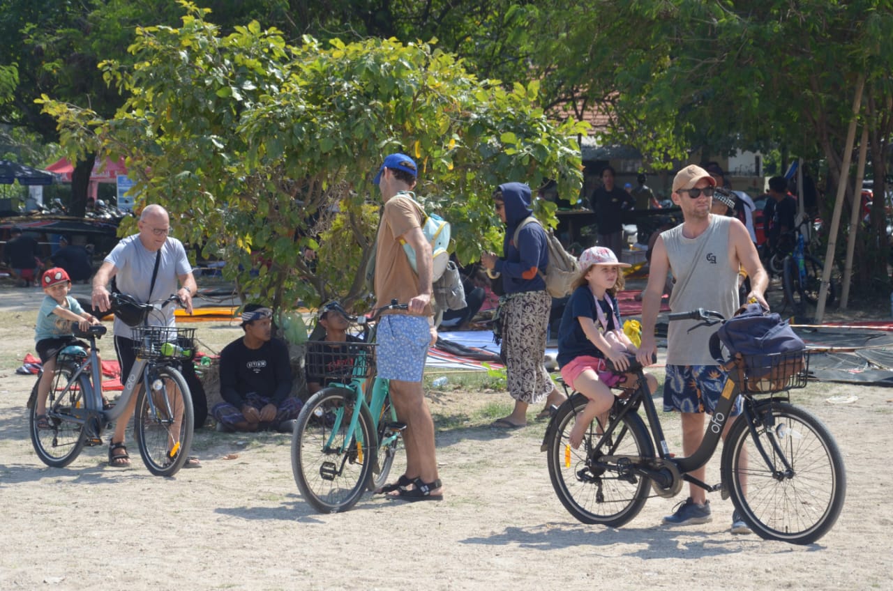 SAYANG ANAK: Sejumlah bule senang bersepda saat menyusuri objek wisata di Bali bersama anak-anaknya.
