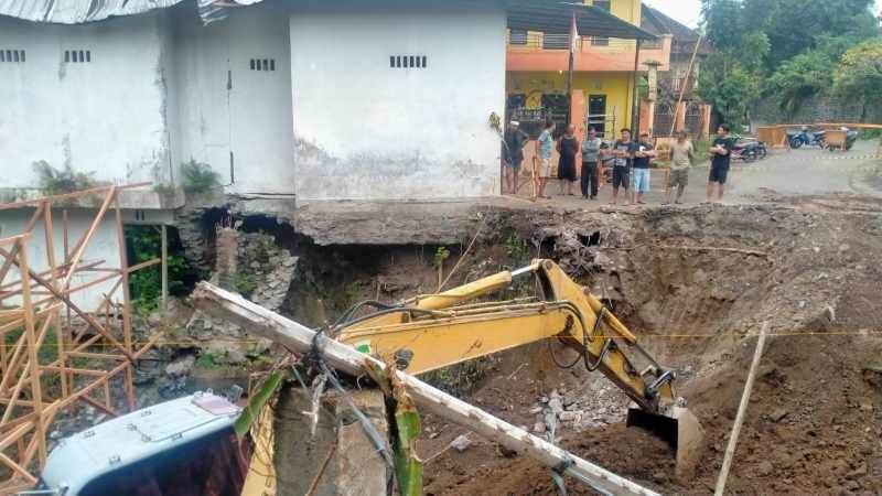 ANTISIPASI BENCANA : Alat berat berupa ekscavator yang mulai mengerjakan pembangunan jembatan di Banjar Dinas Pasekan, Desa Dajan Peken, Tabanan. [juliadi/radar bali]