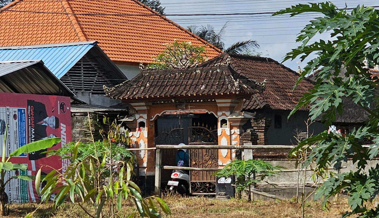 RUMAH TERSANGKA: Aktifitas keluarga tampak seperti biasa, keluar masuk dari gerbang rumah I Wayan Rawan, di Abiansemal Badung Bali Minggu (30/6/2024).