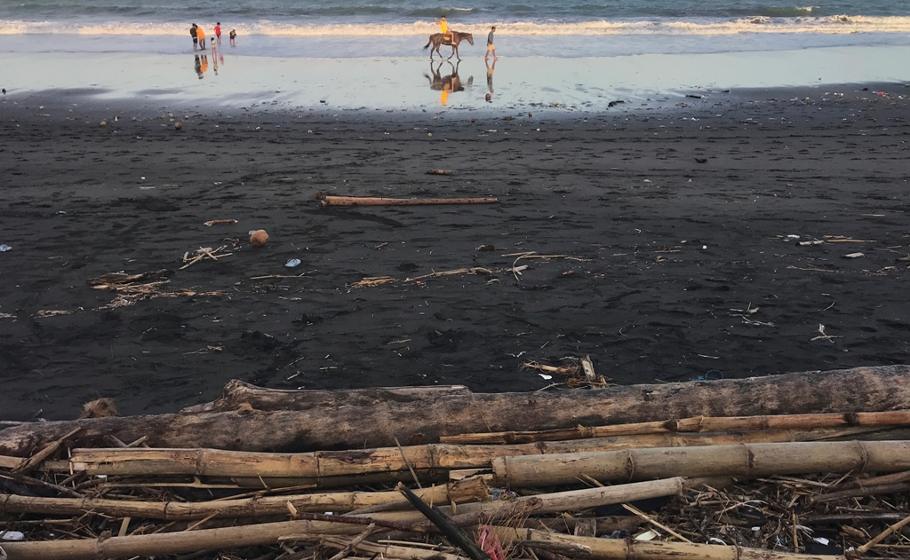 MENUMPUK: Sejumlah sampah terlihat menumpuk di tepi Pantai Padang Galak, Denpasar, Jumat 5 Juli 2024.