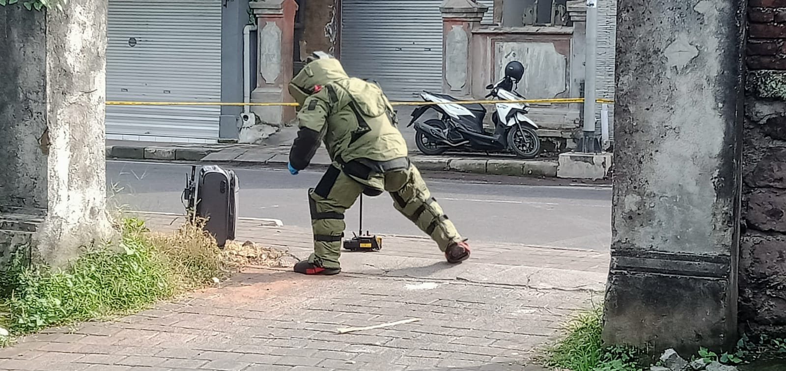 Tim Jihandak Polda Bali dengan alat sensor detektor bahan peledak sedang mendekat koper yang di duga berisi bom di Penarungan, Mengwi Badung