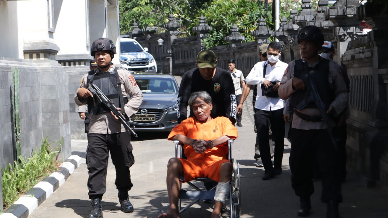 MERESAHKAN: Purwadi, 64, terpaksa duduk di kursi roda menggunakan pakaian tahanan Polsek Kuta Selatan