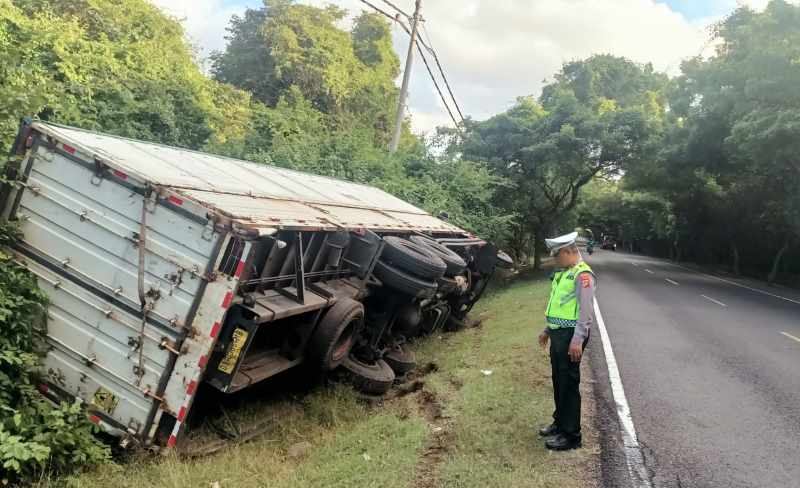 TERGELINCIR : Truk kontainer terperosok ke parit di hutan cekik Gilimanuk. (Foto : Polsek Gilimanuk)
