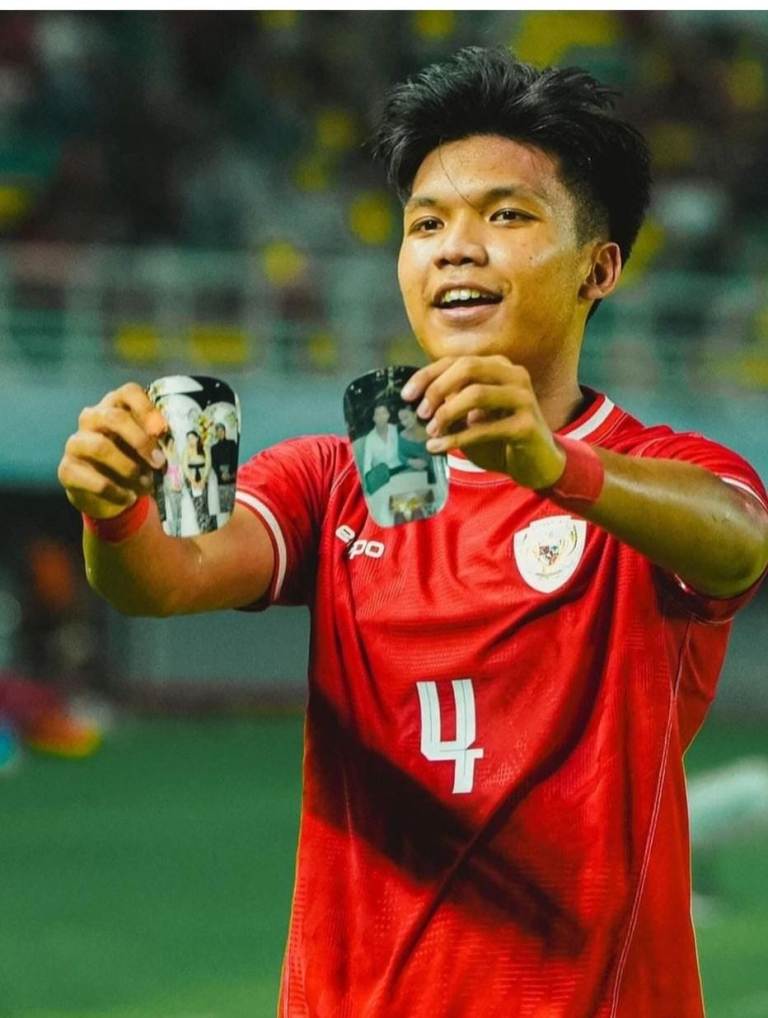 PAMERKAN: Kadek Arel Priyatna  memamerkan dua foto di lapangan usai mencetak gol. Dua foto itu adalah foto keluarganya dan juga foto Kadek Arel bersama pacar.